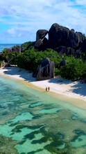 A Couple Of Men And Women Are Walking On The Beach Of Anse Source D'Argent In The Early Morning, A Beautiful Beach In Seychelles. La Digue Island, Seychelles. 
