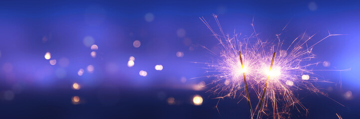 Happy New Year background with glowing sparklers.