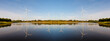 © AU USAnakul+ - Powerful Wind turbine farm for pure energy production on Beautiful clear blue sky with white clouds and wind turbine farm reflection on lake. renewable energy
