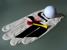 Soft White Leather Golf Glove Close-up With Tee And Marker Peg. Golf Concept. Golf Equipment And Apparel Illustration Condensed In One Image. Leisure And Play.
