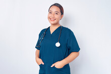 Smiling Young Asian Woman Nurse Wearing Blue Uniform With Stethoscope Holding Hands In Pockets Isolated On White Background. Healthcare Medicine Concept