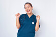 © Bangun Stock Photo - Excited Asian woman nurse wearing blue uniform with a stethoscope showing triumphing and celebrating victory, saying yes, achieving goal isolated on white background. Healthcare medicine concept
