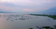 Aerial Panorama View Of Lake With Fishing Farms During Purple Sunrise Behind Cloudscape In Indonesia