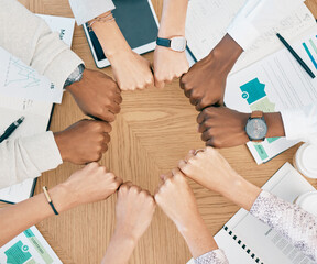 Diversity, fist hands and teamwork with documents on table for marketing business meeting, creative collaboration and goals support motivation. Team, circle hand and planning strategy or logistics