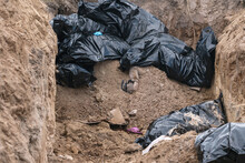 Fragments Of Bodies. Mass Grave Of Civilians Shot By The Troops Of The Russian Army (concept: War In Ukraine)
