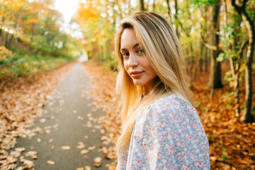 Wall Mural - Portrait of attractive caucasian woman posing in the autumn park.