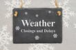 Weather closings and delays message on a chalk sign