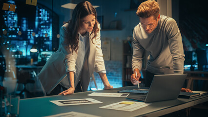 Accountant Bringing a Financial Report to a Meeting with a Marketing Manager of a Creative Agency. Two Young Colleagues Discuss a Project Plan and Work Together as a Team. Late Evening in Office.