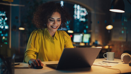 Poster - Close Up Portrait of a Successful Middle Eastern Female Celebrating a Corporate Business Win in Creative Office. Young Stylish Female with Curly Hair Working on Laptop Computer in Marketing Agency.