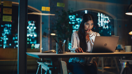 Poster - Indian Female Working in Creative Agency, Implementing Modern Business Strategy for Clients. Successful Specialist Using Laptop Computer at Night in the Office.