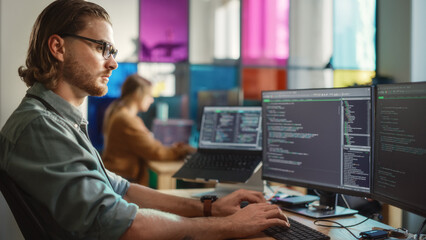 Poster - Caucasian Male Software Engineer Coding on Desktop Computer With Multiple Displays in Creative Office. Young Handsome Man Writing Code For Mobile Application In Tech Start-Up Company.