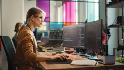 Fototapete - Caucasian Woman Coding on Desktop PC and Laptop Setup With Multiple Displays in Spacious Office. Female Junior Software Engineer Working on New Sprint of Mobile Application Development For Start-up.