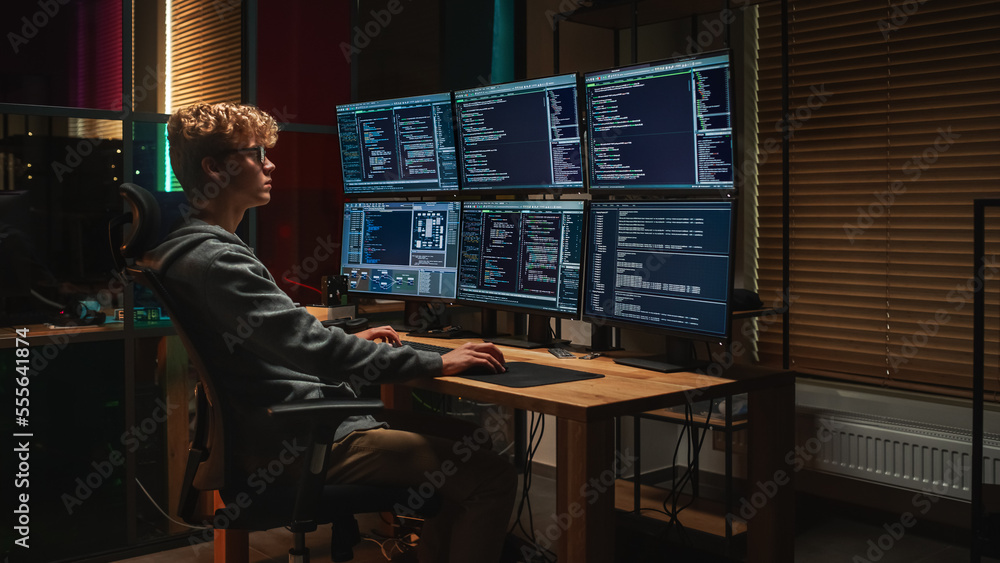Professional tech expert working at computer setup with multiple monitors