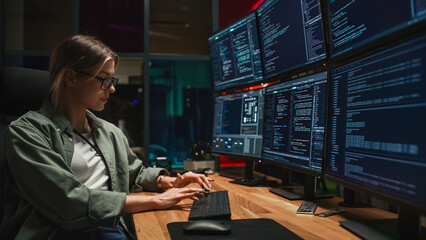 Poster - Female Programmer Coding on Desktop Computer With Six Monitors Setup in Dark Office. Smart Caucasian Woman Monitors Data Protection System For Cyber Security Department IT Company