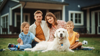 Wall Mural - Portrait of a Happy Young Family Couple with a Son and Daughter, and a Noble White Golden Retriever Dog Sitting on a Grass in Their Front Yard at Home. Cheerful People Looking at Camera and Smiling.