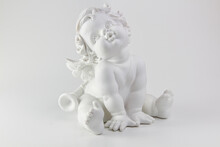 White Figurine Of A Small Cherub Angel Sitting