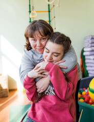 Wall Mural - a girl diagnosed with autism with her mother in a rehabilitation center.