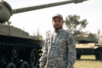 Asian man special forces soldier standing against on the field Mission. Commander Army soldier military defender of the nation in uniform standing near battle tank while state of war.