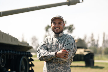 Asian man special forces soldier standing against on the field Mission. Commander Army soldier military defender of the nation in uniform standing near battle tank while state of war.