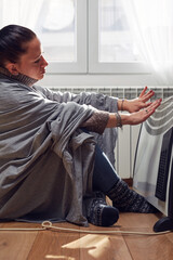 Wall Mural - Woman indoors on a chilly winter day, energy and gas crisis, cold room, heating problems.