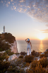 Poster - happy woman sitting at the cliff view view of Lefkada island lighthouse