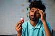© WESTOCK - close up shot, young man got relief after applying balm or ointment to forehead due to headache or migraine while sleeping at night - concept of pain relief, treatment and medications