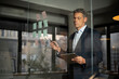 © JustLife - Portrait of successful businessman in office. Man writing ideas on colorful stickers on glass wall.