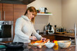 © ADDICTIVE STOCK - Content adult woman cooking in modern kitchen