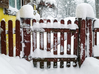 Poster - A snowy wooden gates and fence on a sunny winter day.