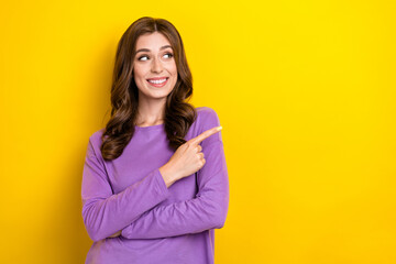 Photo of young attractive cute dreaming lady toothy beaming smile finger point empty space information isolated on yellow color background