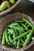 Portion Of Freshly Picked Okra On Bowls Of Different Materials Over Rustic Table. On Brazil Countryside