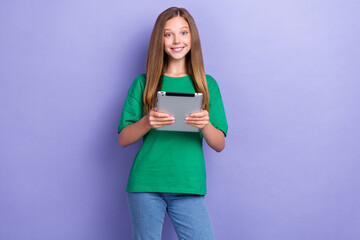 Wall Mural - Photo of positive lovely pretty lady schoolkid use modern tablet ipad writing text sms message isolated on purple color background
