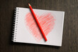 © Designpics - heart shaped drawing on notebook and colored pencil, wooden background, studio shot