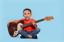 Cute African-American Boy With Electric Guitar On Turquoise Background