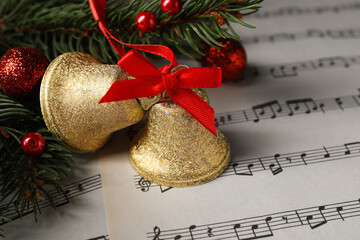 Sticker - Golden shiny bells and fir branches with Christmas decor on music sheets, closeup. Space for text