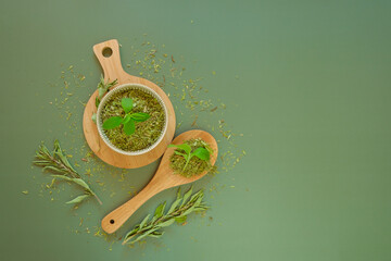 Wall Mural - Dried stevia and green twig in a round cup and a wooden spoon.Sugar substitute.Stevia rebaudiana.Stevia plant. Low Calorie Vegetable Sweetener. Natural dietary sweetener.