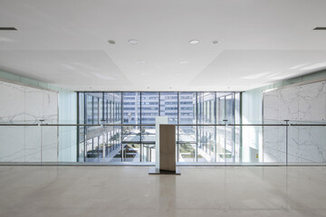 Poster - Atrium of an office building with green marble tiled walls, cream marble floors viewed from a mezzanine bay window with glass railing