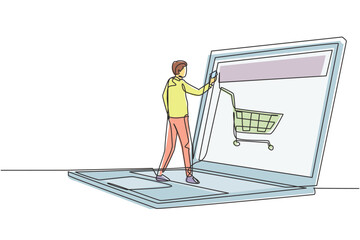 Wall Mural - Single continuous line drawing young male shopping online via giant laptop screen with shopping cart inside. Sale, digital lifestyle concept. Dynamic one line draw graphic design vector illustration