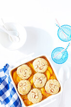Peach Almond Cobbler With Blue Checkered Napkin And Blue Cups With Straws, Studio Shot On White Background