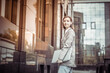© splitov27 - Informal, young business woman with a laptop walks through the city on the background of a business building