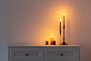 Wall Mural - burning candles on white wooden shelf in white interior