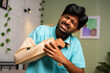 © WESTOCK - Medium shot of Young man suffering from broken or injured hand at home - concept of medical or health care treatment, injury and rehabilitation