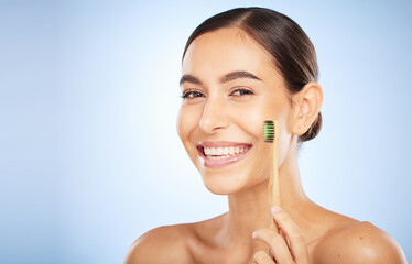 Face portrait, dental and woman with toothbrush in studio isolated on a blue background. Oral wellness, veneers and happy female model holding product for brushing teeth, cleaning and oral hygiene.