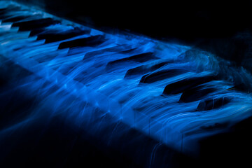 white keyboard piano covered by blue light