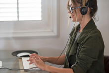 Side Portrait View Of Happy Woman Smiling And Writing On Keyboard Wearing Headphones Set And Microphone To Call And Listen Clients. Modern Job Business Lifestyle And Smart Working Office Activity