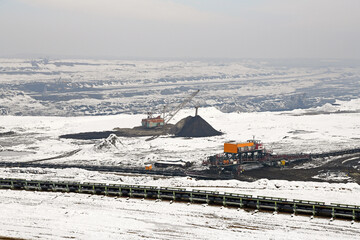 A huge excavator on a surface coal mine in winter conditions. Interesting appearance of surface mining under snow.