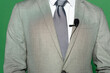 © LIGHTFIELD STUDIOS - cropped view of news anchor in suit and clip microphone standing on green