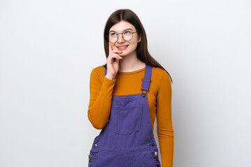 Wall Mural - Young Russian woman isolated on blue background thinking an idea while looking up