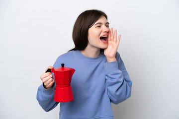 Wall Mural - Young Russian woman holding coffee pot isolated on white background shouting with mouth wide open to the side