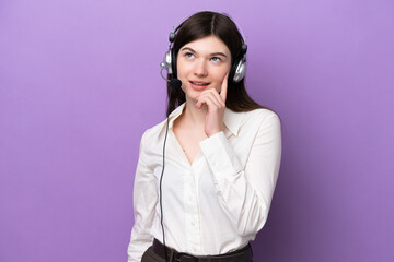 Wall Mural - Telemarketer Russian woman working with a headset isolated on purple background thinking an idea while looking up